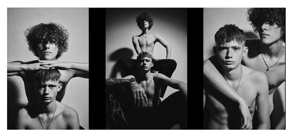 Three portraits of two shirtless young men, one with curly hair, the other tattooed, in hard light with wall shadows