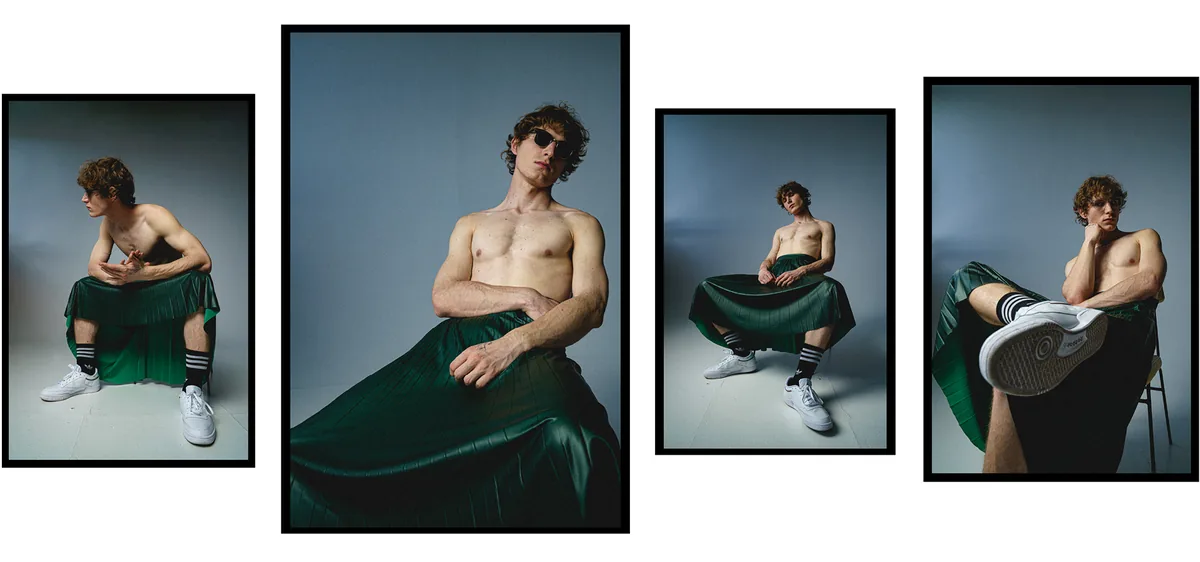 Four frames of a shirtless man in a green pleated skirt and white sneakers, posing seated on a stool in a blue-grey studio
