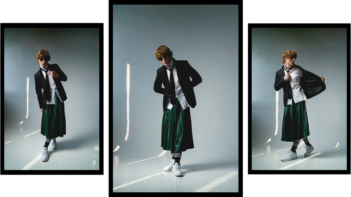 Three frames of a man in a blazer, tie, sunglasses and green pleated skirt, in a pale studio with streaks of light