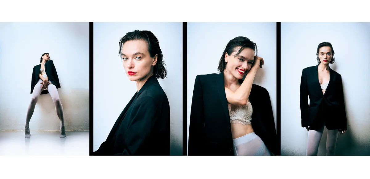 Four frames of a woman with slicked-back hair and red lips in an oversized black blazer and white tights against a white wall